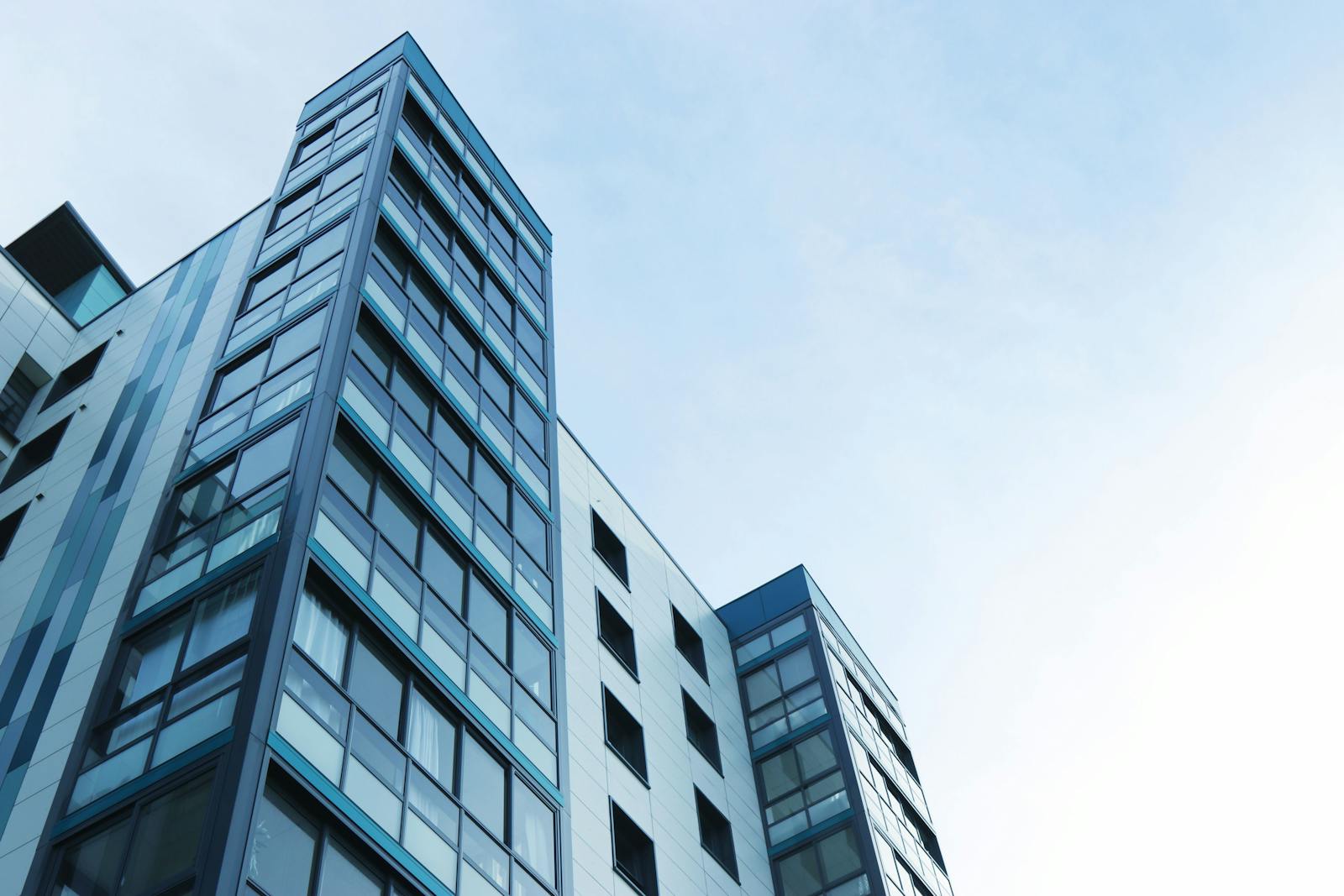 Low-angle view of a modern glass skyscraper against a clear sky in Poole, UK.